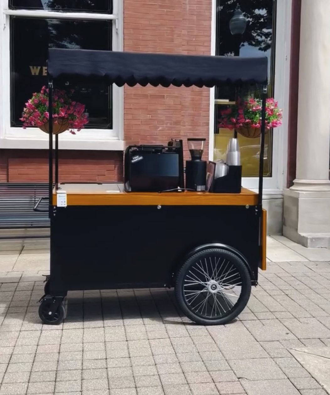 Skully, the SkullFlower mobile coffee cart, set up on a Franklin sidewalk with flower baskets